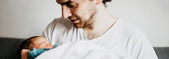 un père tient son nouveau-né dans les bras
