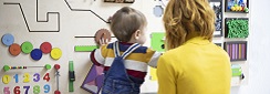 Une femme joue avec un enfant dans un lieu d'accueil ludique