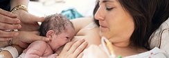 Femme qui allaite un nouveau-né avec l'aide d'une professionnelle