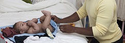 un père change la couche de son bébé sur un lit