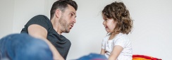 Adulte en train de parler à un enfant de 2 ans, visages à niveau. 