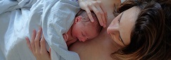 une femme avec son nouveau-né posé sur elle à la maternité