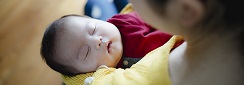 un nourrisson apaisé qui dort dans les bras d'une femme