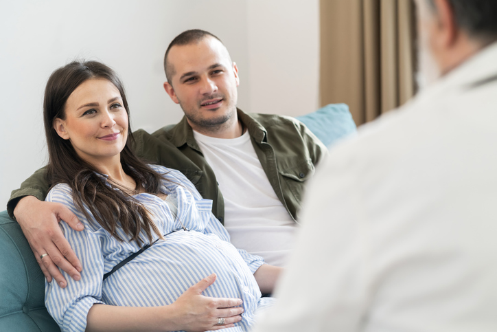 une femme enceinte et son compagnon en consultation avec un professionnel de santé