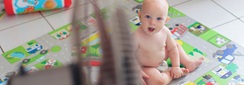 un bébé en couche devant un ventilateur dans le salon