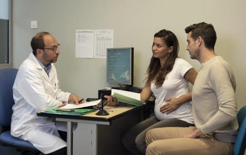 un couple dont la femme est enceinte dans le bureau d'un professionnel de santé