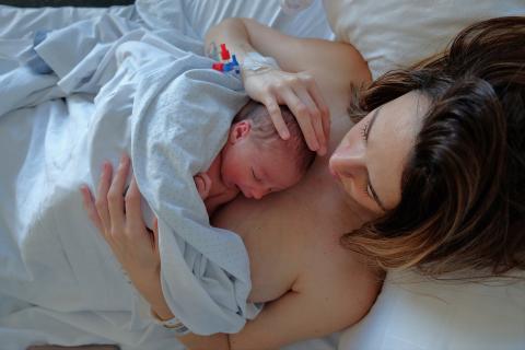 une femme avec son nouveau-né posé sur elle à la maternité