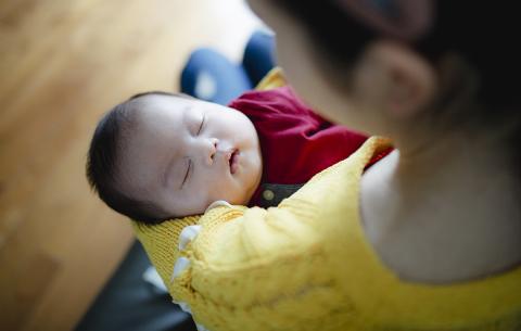 un nourrisson apaisé qui dort dans les bras d'une femme