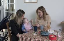 deux femmes dont une donne à manger à un bébé