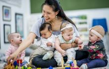 Une femme s'occupe de 4 bébés d'environ le même âge