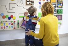 Une femme joue avec un enfant dans un lieu d'accueil ludique