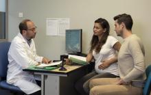 un couple dont la femme est enceinte dans le bureau d'un professionnel de santé
